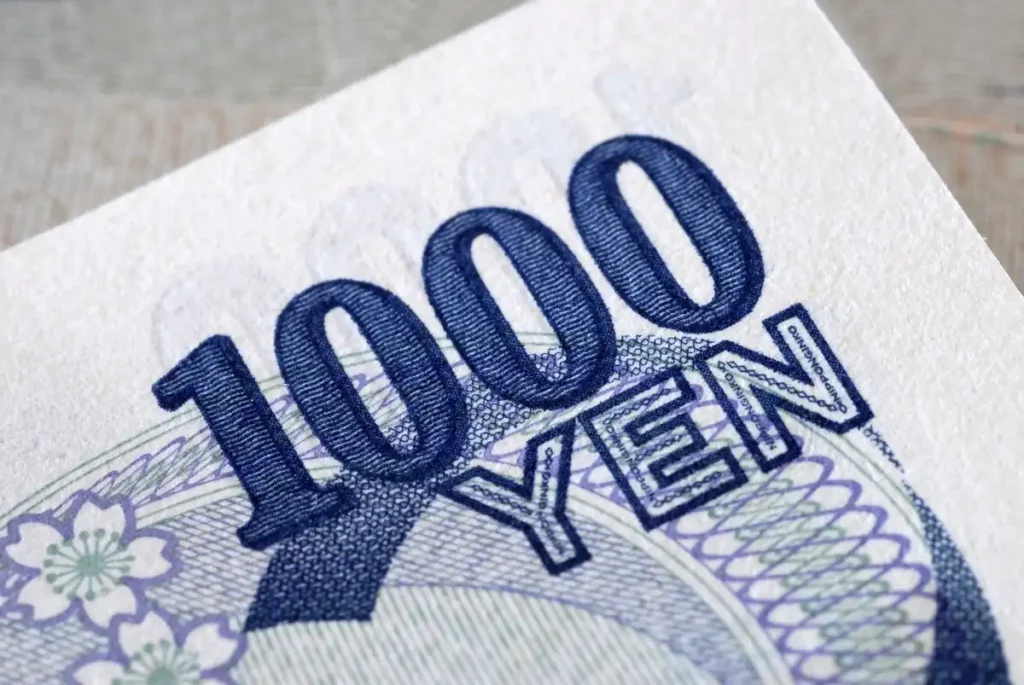 Close-up of a 1000 Japanese Yen banknote showing detailed print, currency symbol, and cherry blossom pattern