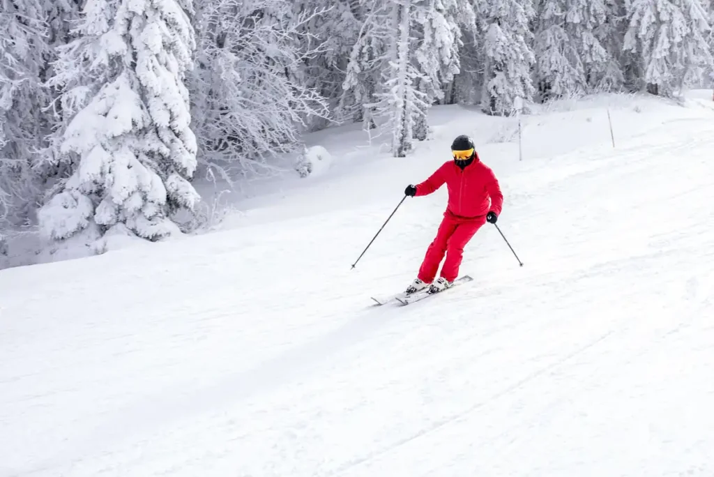 japan Weather-“Skiing in Japan during winter season – skier in red outfit gliding down a snowy slope in Hokkaido’s powder snow”