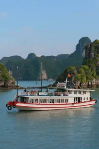 Tourist cruise boat sailing through Ha Long Bay, Vietnam – a popular activity for first-time travelers exploring the bay’s limestone islands.-Vietnam bucket list