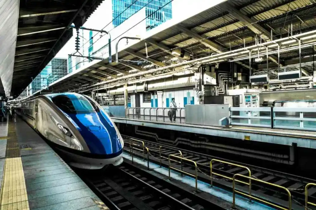 A sleek blue and silver Shinkansen bullet train at a modern platform in Japan, ready for high-speed departure- japan travel